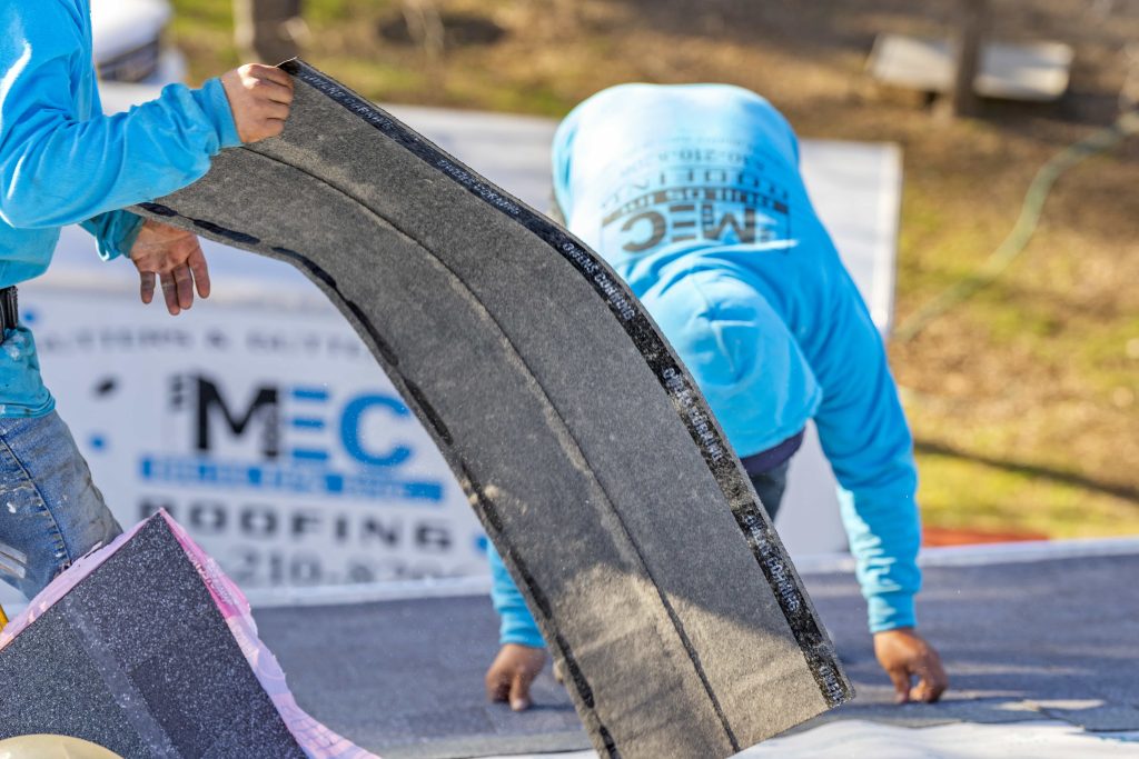 MEC Builds workers holding roofing shingles