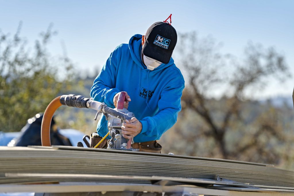 MEC Builds worker doing roofing maintenance